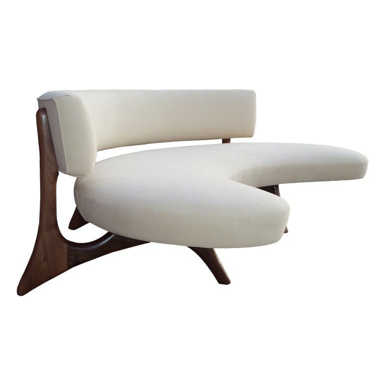 A biomorphic walnut sofa with curved backrest and a floating platform seat set on sculptural carved legs which blend seamlessly into the support for the back.
A reproduction inspired by the amazing design of Vladimir Kagan.