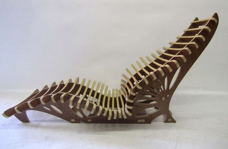 This prototype chaise lounge with matching ottoman is artfully rendered in walnut plywood with a pierced base that supports numerous slats resembling vertebrae.The artist is unfortunately unknown (by us at least!) but it a beautiful work and it will