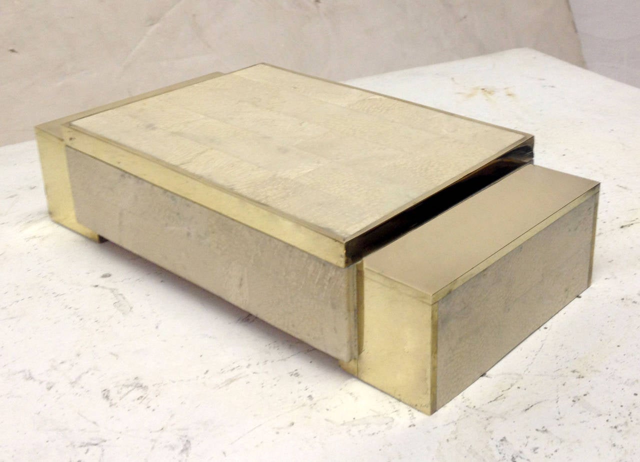 An architectural jewelry box exquisitely rendered in brass and tessellated stone. The beige lining of the box has a small tear, shown in photos.