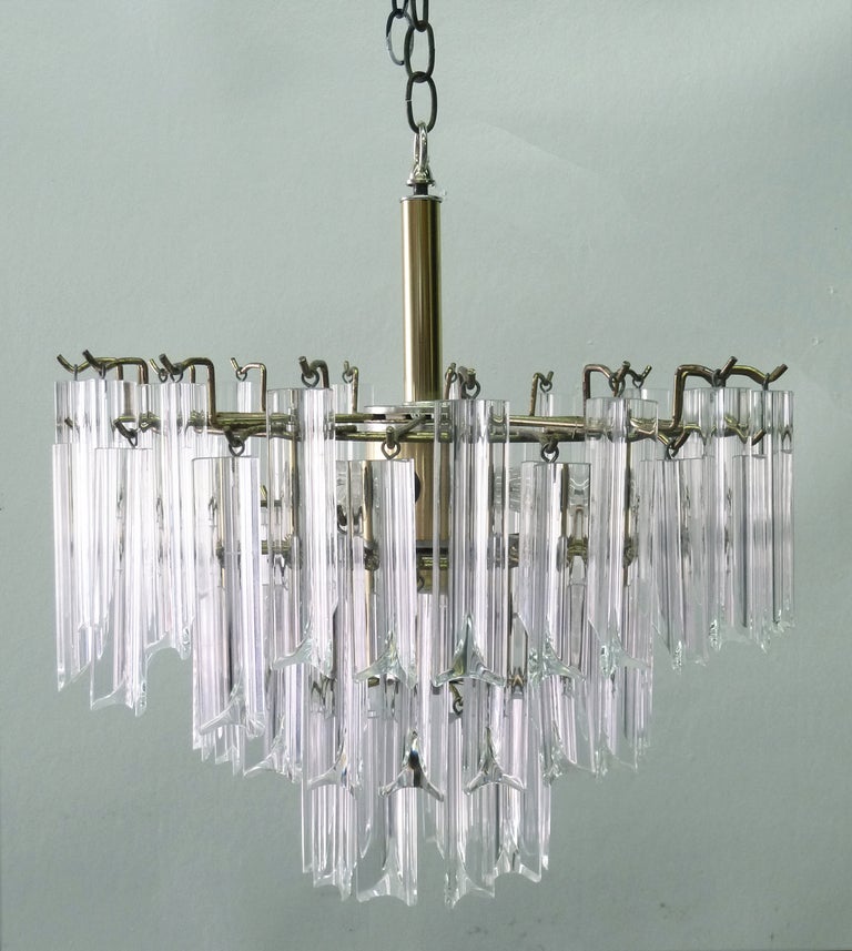 Glistening chandelier from the 1970's made of shaped lucite crystals and a chromed framework. The light source bounces the light from the central hub, reflecting throughout the lucite.