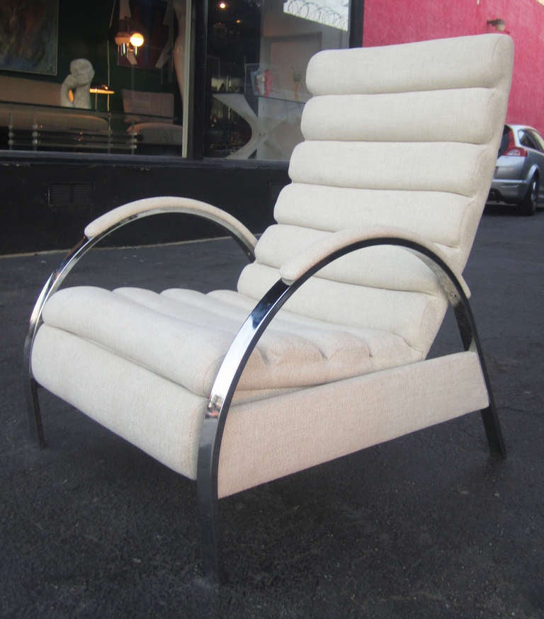This sculptural recliner by George Mulhauser features chaneled upholstery with rounded chrome armrests upholstered at the top in the same material.