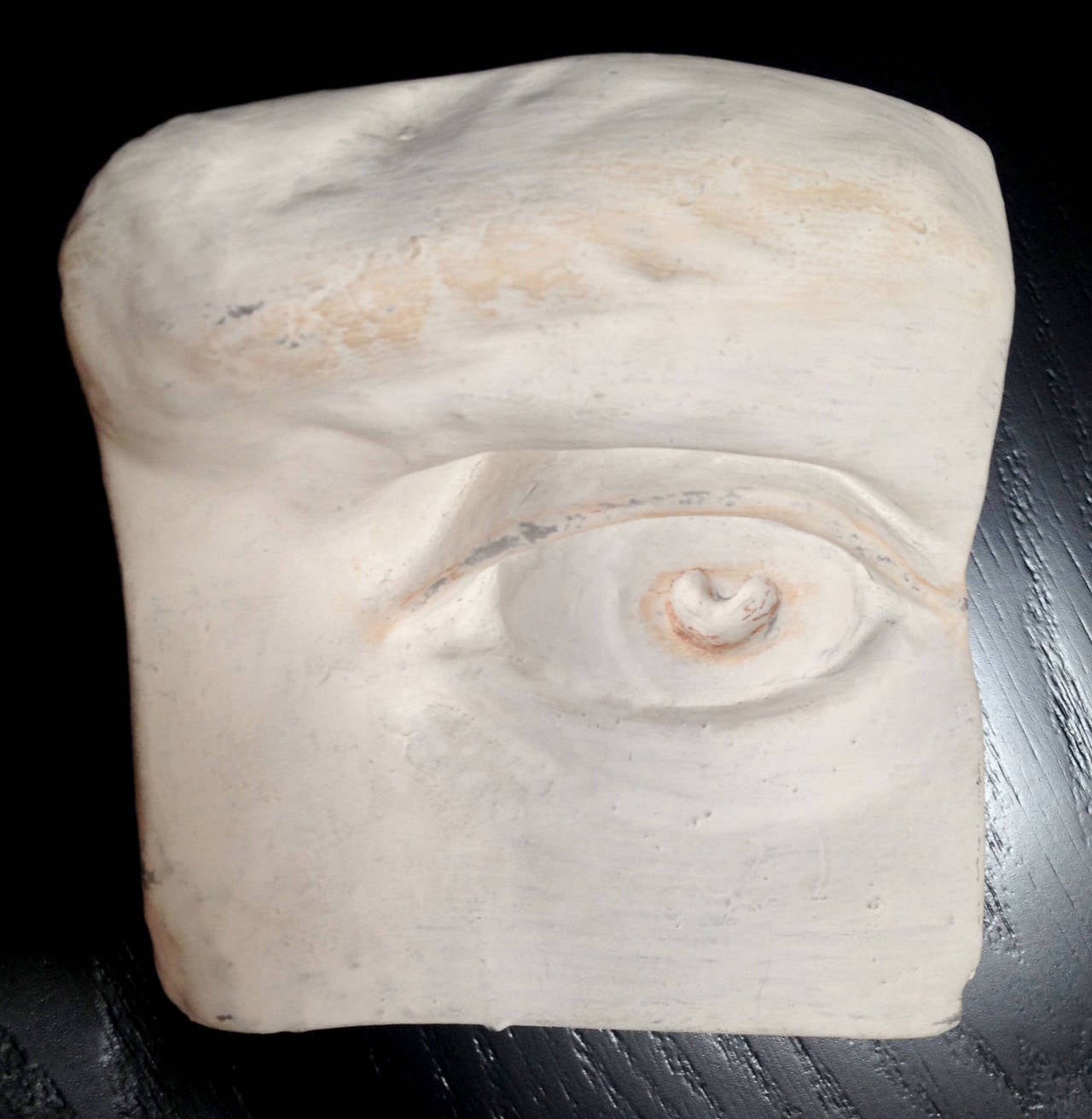 A set of four fragments of a classically sculpted face rendered in plaster. The eye, nose, ear and mouth can be used as tabletop decoration or can be hung on a wall. 
The indicated measurements are for the eye.
The ear is 8