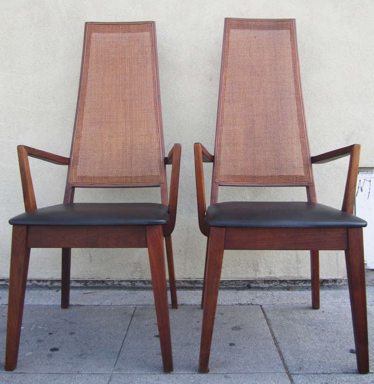 Ces fauteuils architecturaux du milieu du siècle dans le style de John Keal présentent des accoudoirs anguleux et de hauts dossiers en canne. Les sièges rembourrés sont en vinyle noir. Fabriqué par la défunte société Tempo de Californie.