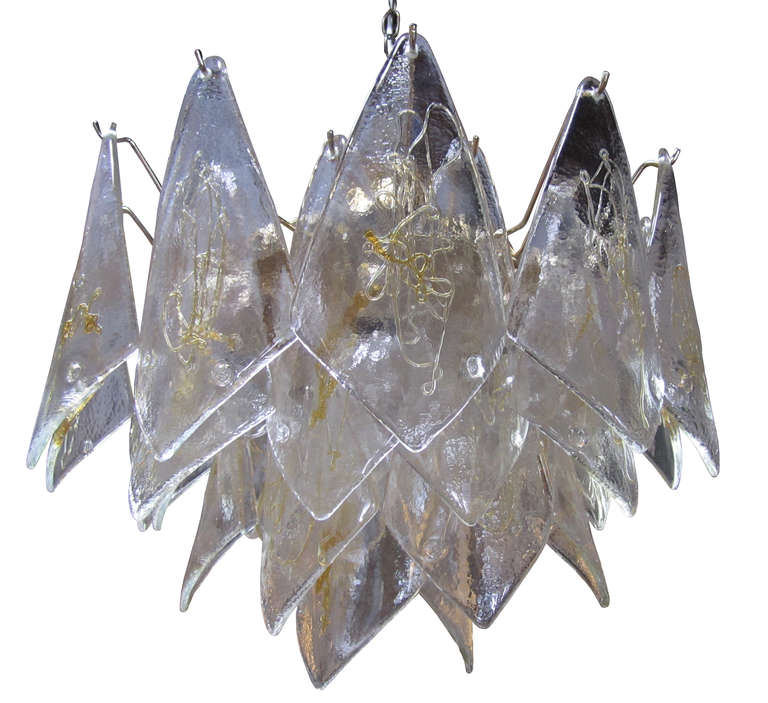 This La Murrina Murano chandelier is comprised of a central brass frame which supports a cluster of diamond-shaped glass pieces. Each curved paillette is emblazoned with a stamp and a golden design which delicately contributes to the chandelier's