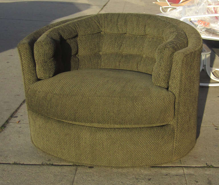 This classic barrel-back chair by Milo Baughman sits on a swivel base and features a tufted back cushion. The chair is upholstered in its original, checked olive green upholstery.