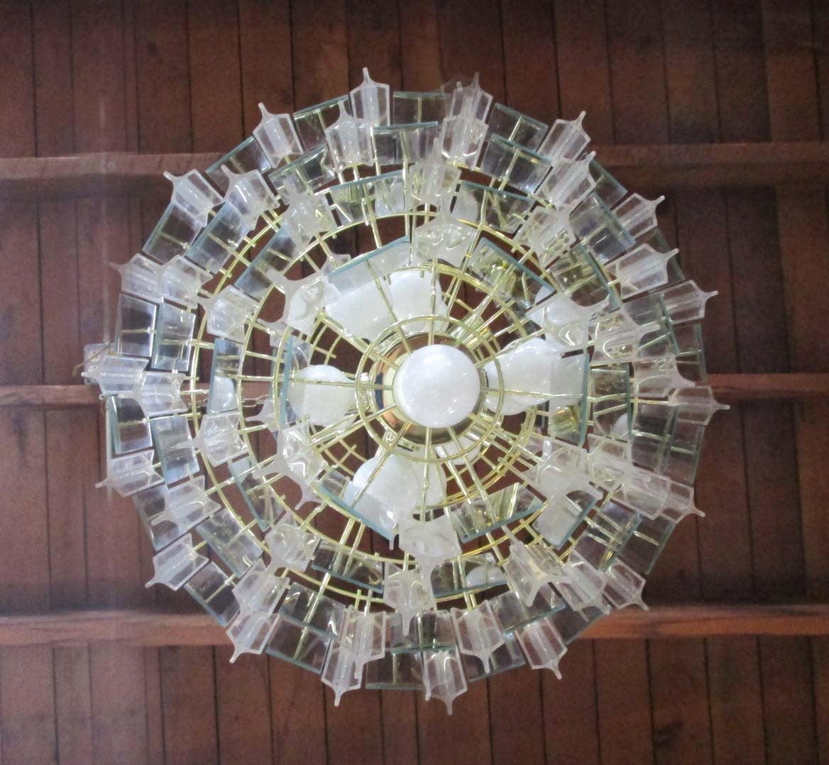 5 Tier Lucite Resin and Glass Pendant Chandelier all hanging from a brass plated frame
Holds up to 15 Bulbs. Each glass pendant features a mirror centered.
A chandelier hangs from a chain which can be any length, determined by ceiling height and
