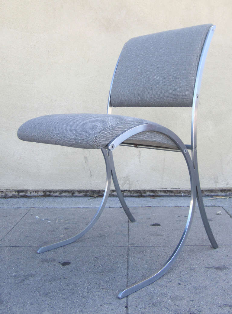 This set of six, French dining chairs by Maison Jansen feature elliptical, polished steel frames. The seat and back are newly reupholstered in a gray woven fabric.