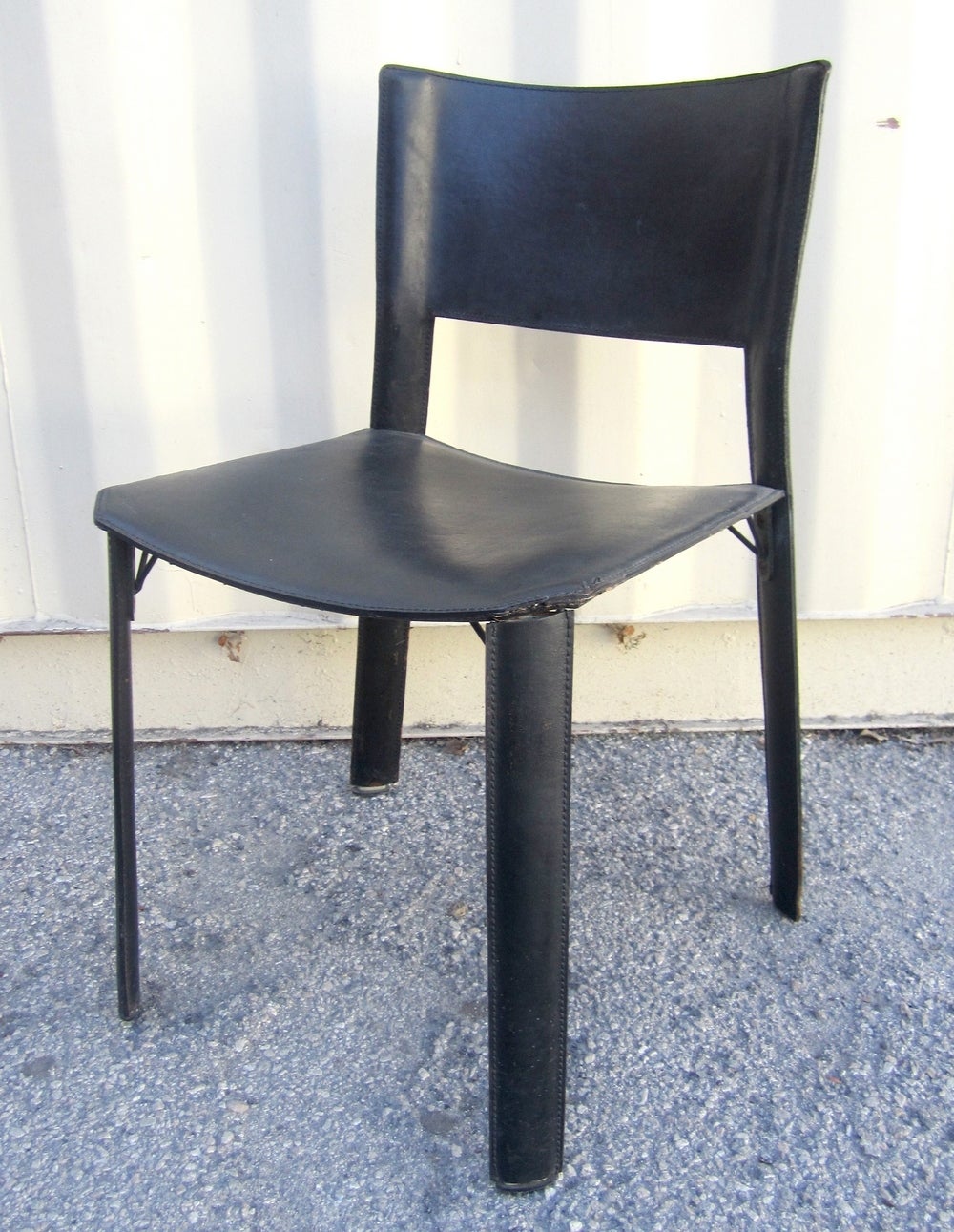 4 black leather dining chairs in the manner of Mario Bellini.