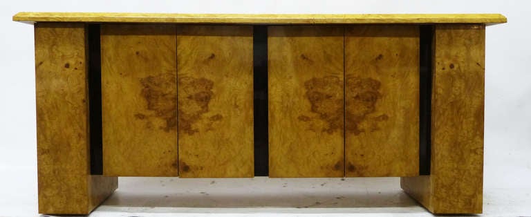 This handsome 1970s bar or cabinet features a pair of cabinets flanked by pull out shelving compartments intended for bottles or glasses. The burled wood finish is outlined on top by an ebony-toned thin band; wider vertical bands separate each of