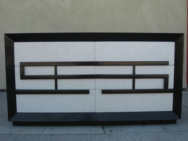 A black lacquer Greek key chest of drawers, designed for Kittinger. The front of the drawers is covered in white leather.