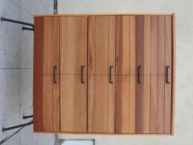 If you like wood this is a perfect specimen. The dresser's wood  has a variety of tones and grain patterns.  The wood goes from dark mahogany to blonde to almost white.<br />
The legs and handles are in black iron.<br />
The matching dresser is