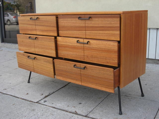 Very minimalist design, typical of this Raymond Loewy period. He radically changed in the 60s.
The wood is beautiful because its tones are different in the same piece. Legs and handles are made black iron.
