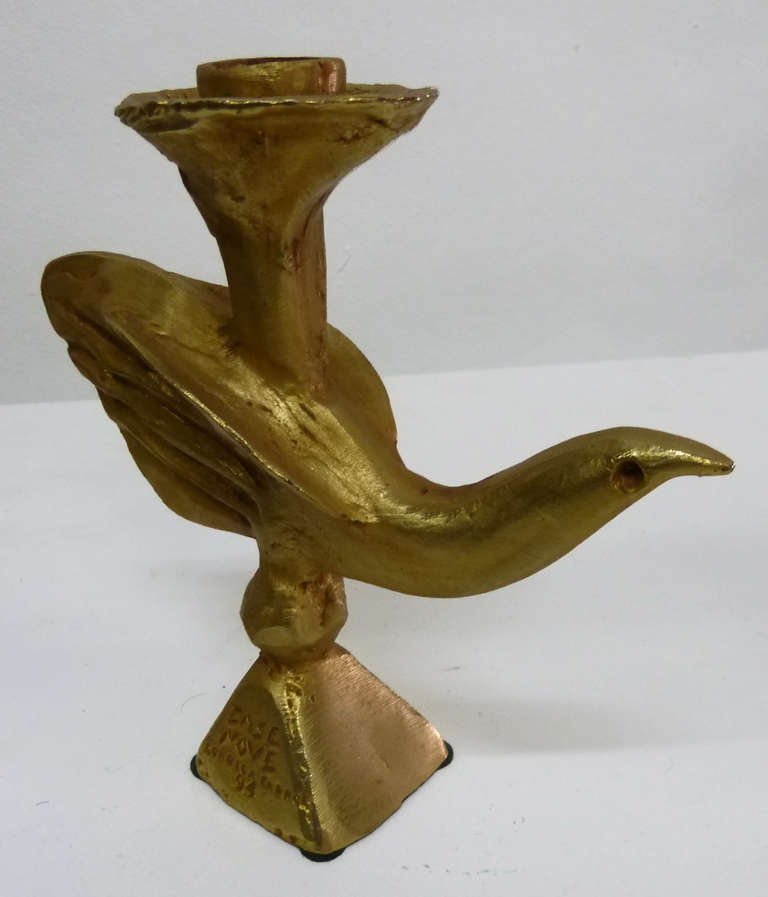 This  candlestick  by French artist Pierre Casenove is made of gilt bronze . The pyramid base is marked with the inscription, 