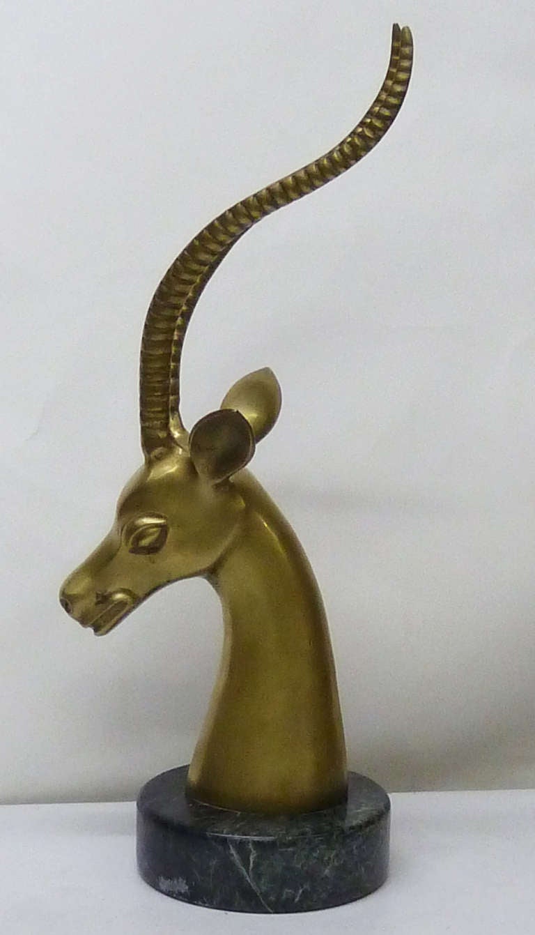 This elegant, mid-century modern table sculpture of a stylized gazelle is skillfully rendered in solid brass and rests upon a circular base of green Italian marble. 