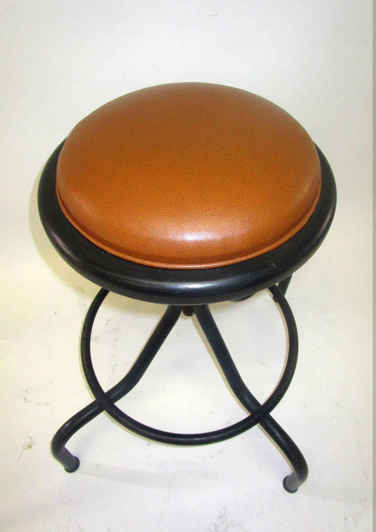 Industrial style set of 4 black metal adjustable work bench stool with brown leather upholstered seat.  Sitting on matte black powder coat original finish frame. Adjustable height by turning of knob.

Seat Diameter: 15