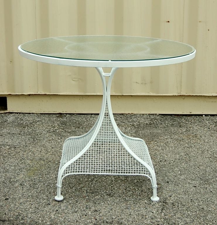 A charming set of 4 iron garden chairs and matching table with lovely curved legs, mesh seats and backs and ball finials. The table top has the original water wave glass and sits firmly. Classic and modern design for California living.
