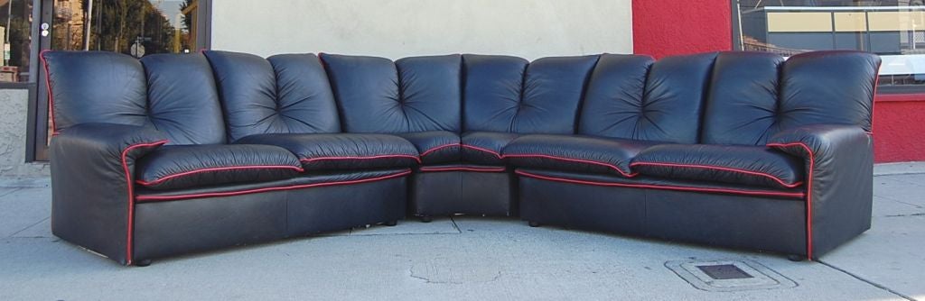 The sofa sections off in three segments, the smallest part existing in the middle. Great detailing with the red piping from the front to the back and a very comfortable tufted backrest.