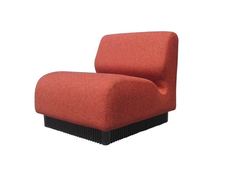 Two slipper chairs from a modular seating system designed by Don Chadwick for Herman Miller in 1974. The chairs, which rest on a ribbed plastic base, feature new upholstery.