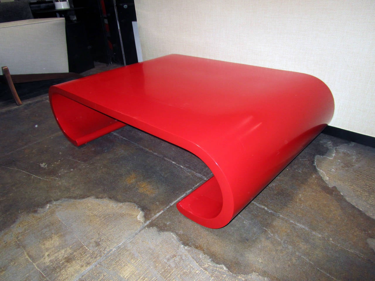 This Asian inspired, scroll cocktail table attributed to Karl Springer features a glossy, red lacquer finish. This modern coffee table would add a distinctive pop of color to your living or office space.