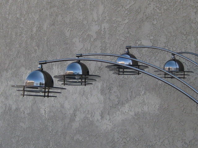 1970’s floor lamp with 4 adjustable arm light sources. The lamp is patinated in gunmetal black. The structure of the lamp is weighed down by a U-shaped base allowing for the lamp arms to move with ease. The lamp heads also have a pivoting joint that