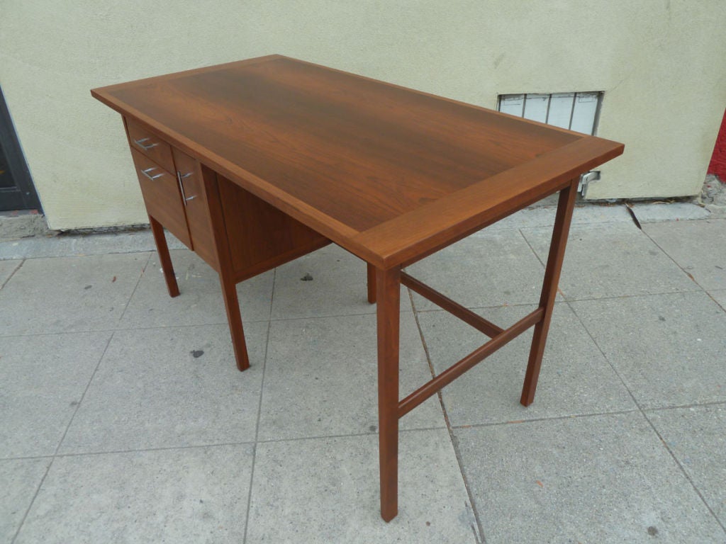 Secretaries desk designed by Paul McCobb for Lane furniture Co. from the 1960's. The desk has left hand facing storage drawers with brushed steel hand pulls. One of the pulls is designed to be  vertical with the other two designed to be horizontal. 