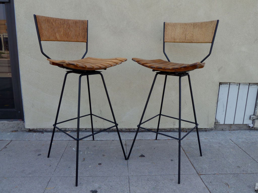 Pair of iron and wood slat bar stools with rush backs.<br />
They have been designed by Arthur Umanoff for Raymor