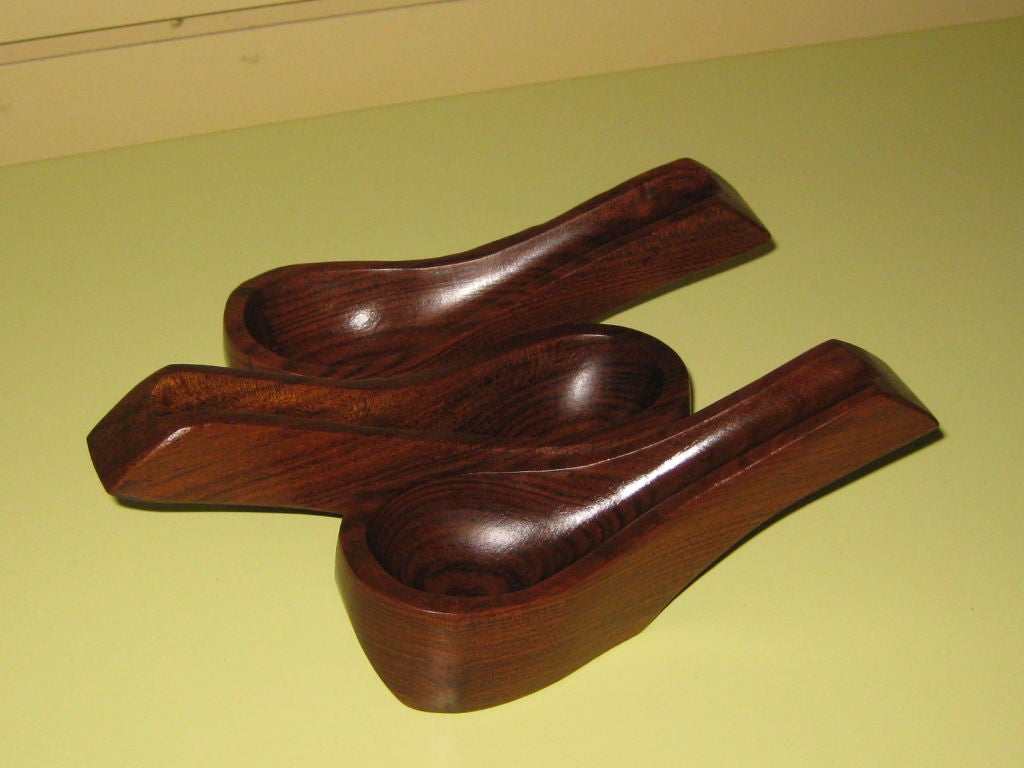 A pipe rack which looks like 3 pipes sculpted in rosewood. It wears the label