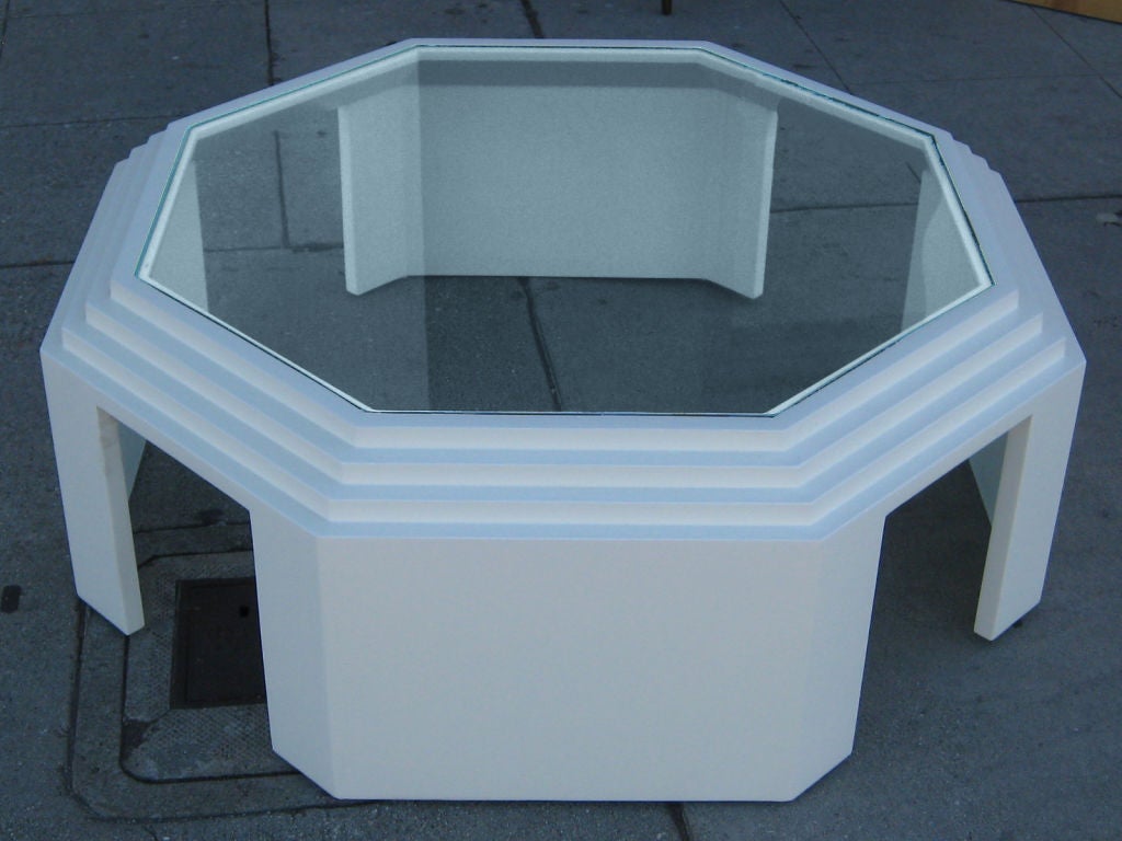 White lacquer coffee table with a clear glass top.