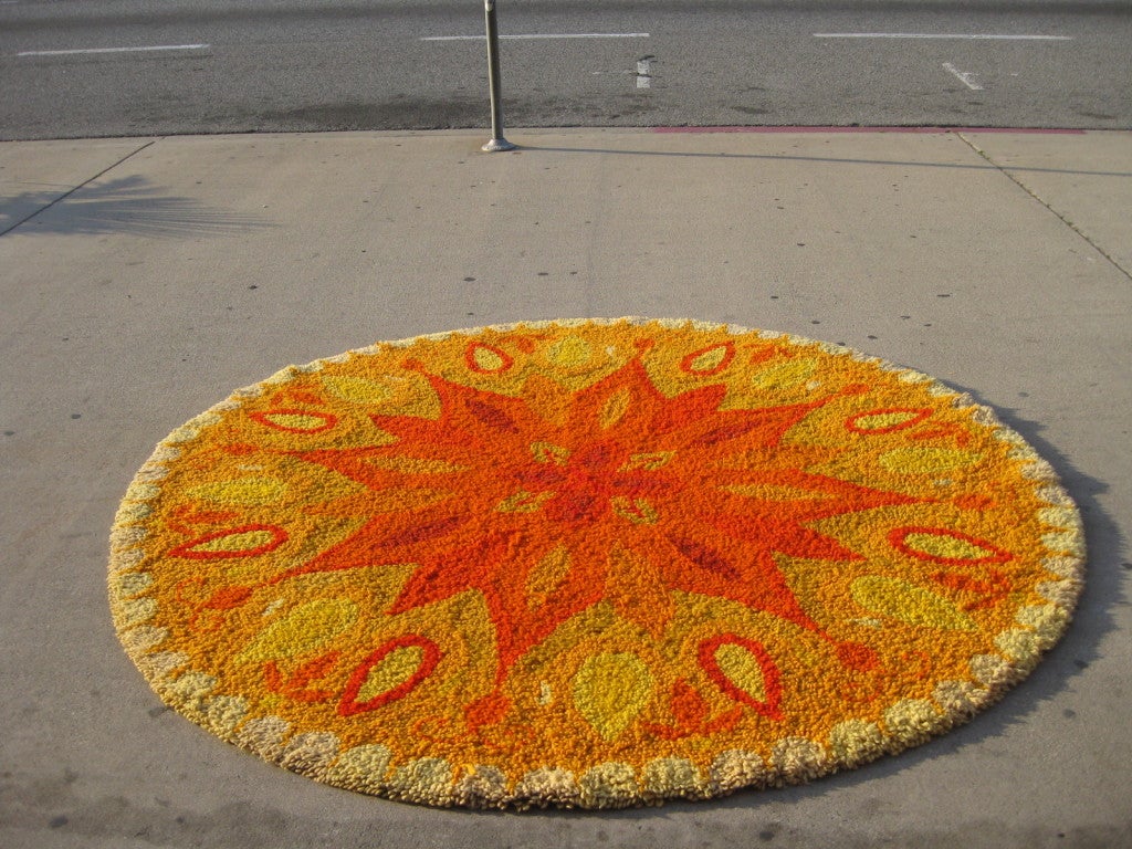 Here is a rare, circular rug from the 1960s in excellent condition. Radiating from the center is the large, sun motif fashioned in a dense looped pile.