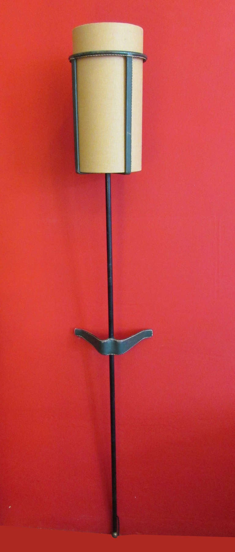 This rare wall light by French Modernist, Jacques Adnet, is rendered in enameled metal and brass with a linen shade and the designer's signature leather accents throughout. 
Literature: 
