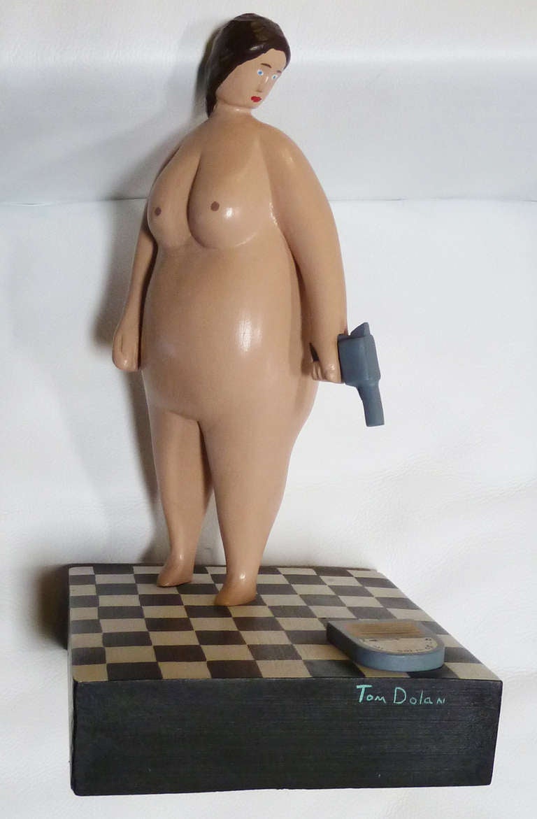 This sculpture by listed American artist Tom Dolan amusingly depicts an overweight, nude woman aiming a gun at a scale on the floor. Based in Minneapolis, Minnesota, Dolan (b. 1943) has exhibited at various folk art museums across America and is the