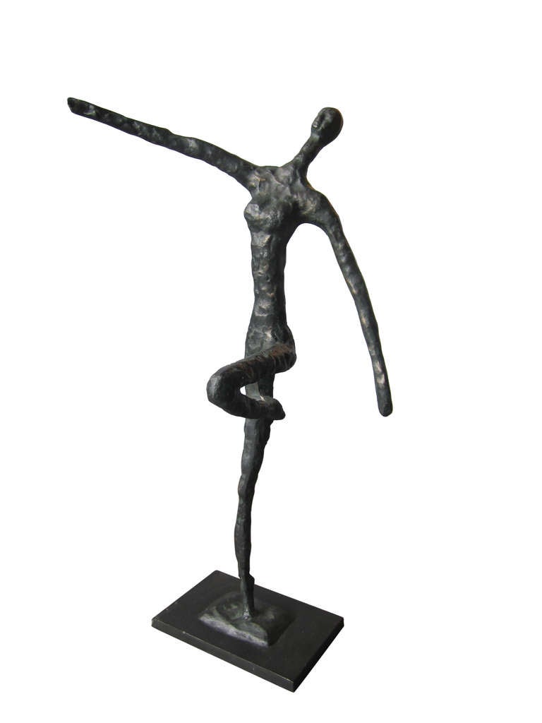 This table-top sculpture in cast bronze depicts a woman balanced gracefully on one leg. The attached base is also in cast bronze. 
The piece is unsigned.
