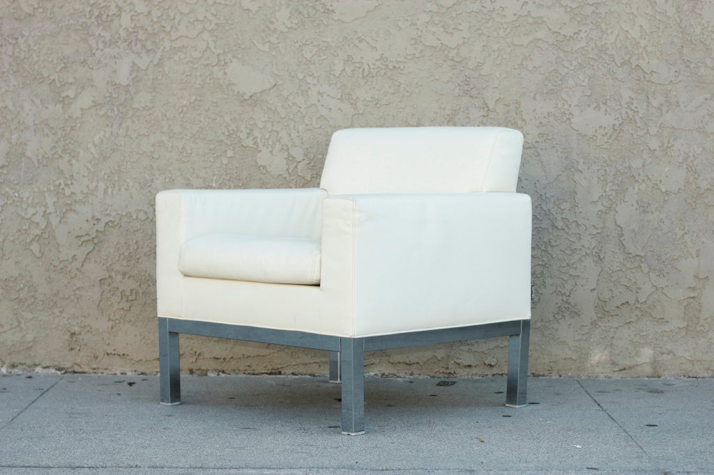 These sharply designed, comfortable lounge chairs feature high quality upholstery in thick yet supple white leather. Each base, including the squared legs are finished in chrome.