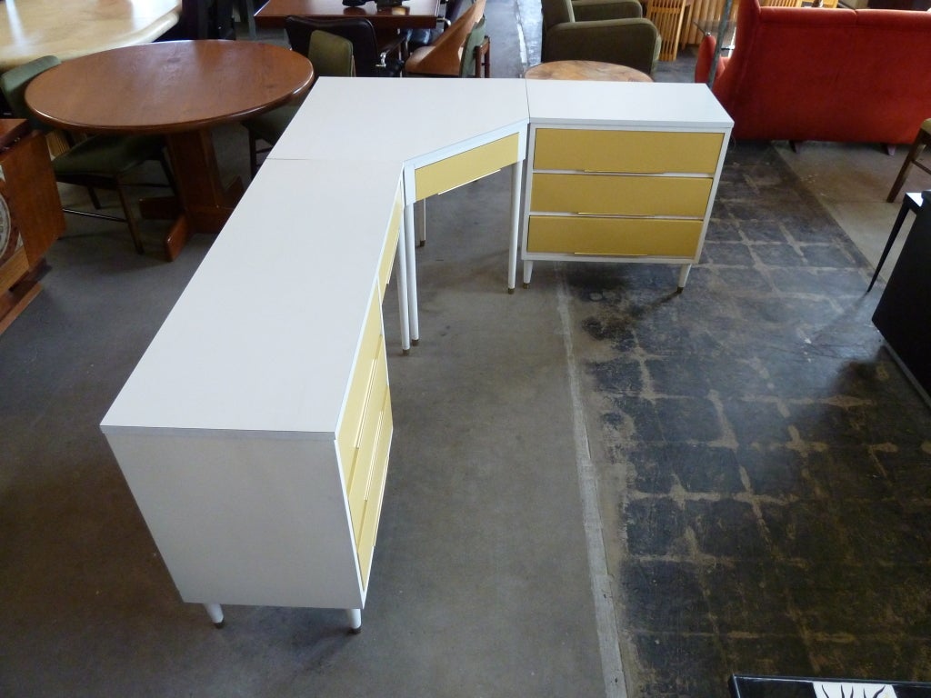 This mid century modern modular desk set is composed of three pieces which may be configured to best fit your space while accommodating two sitters. The components are: a desk with three side drawers and one top drawer, a corner section with a