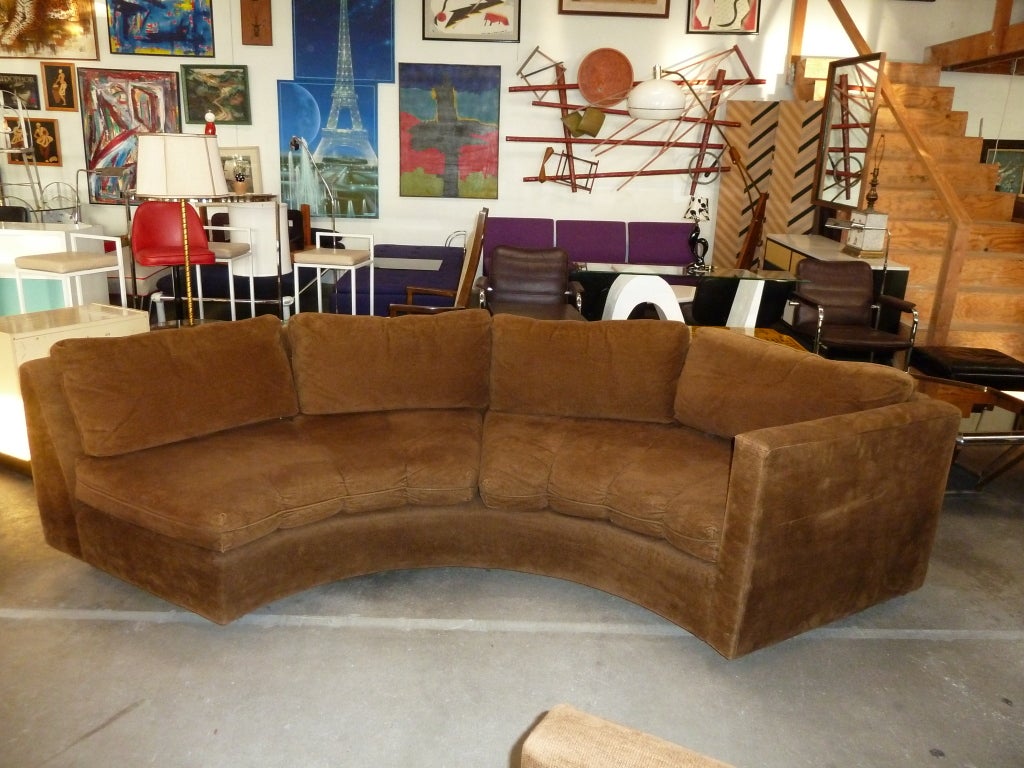 This crescent shaped, two piece modular sofa accommodates at least eight people and features its original brown corduroy upholstery. The pieces may be separated (as shown in images) to fit into more compact spaces. The sofa is extremely comfortable.