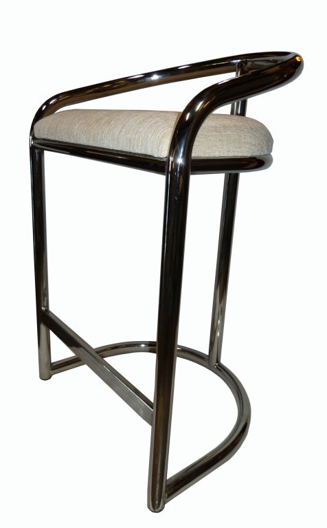 These 1970s stools feature a tubular chrome frame with a back and base in the form of a horseshoe. The structure is elegantly supported in the back by a single vertical support with a flat horizontal stretcher in front to rest one's feet on. The