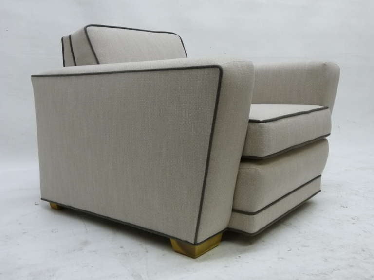 This  lounge chair with rare matching ottoman  features the distinctive angularity of the Paul Frankl speed chair.
Newly recovered in a complementary fabric, the chair is grey with dark grey piping while the ottoman is the opposite.
 The ottoman is