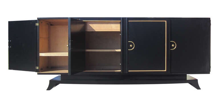 This 1940s buffet from France features an ebonized casing delineated by sycamore banding and brass fittings. Behind each of the four doors are two adjustable shelves made of sycamore as well as the all interior; inside the central cabinets are small