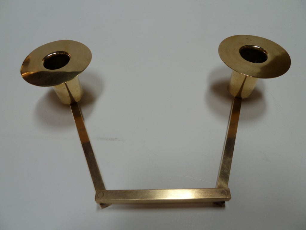 This midcentury modern dual candle holder designed by masterful Viennese designer Carl Auböck (1900-57) features articulating arms which allow the user to adjust the position of the light as needed. Handcrafted in brass, the piece exemplifies the