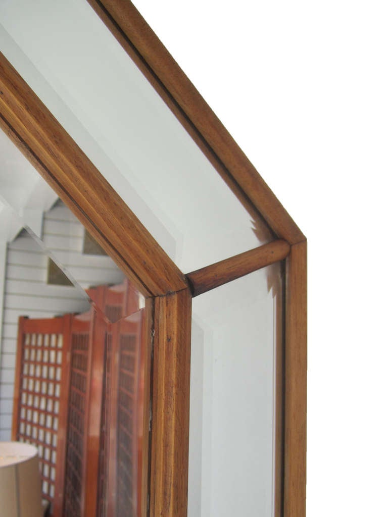 This wall-hanging octagonal mirror features thin wood piping that separates 9 beveled mirror pieces.