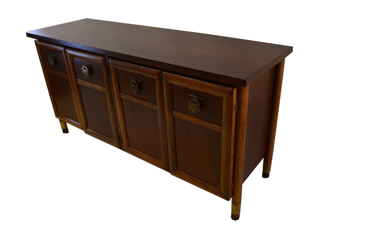 This American of Martinsville credenza is made of walnut and features 1 shelf on the left side and a silverware drawer on the right side. It is unusual by its hight.
The hardware is in solid bras.