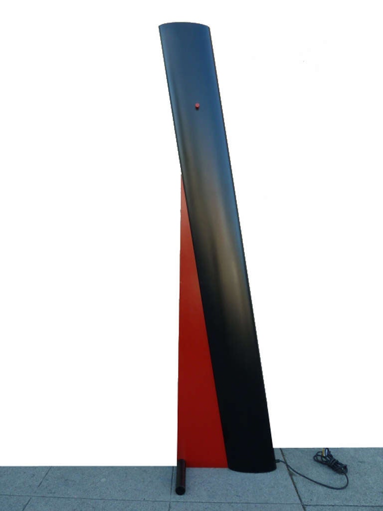 Designed by Ron Rezek, this rare, asymmetrical standing lamp is strikingly sculptural. The red and black torchiere features a twist knob dimmer.