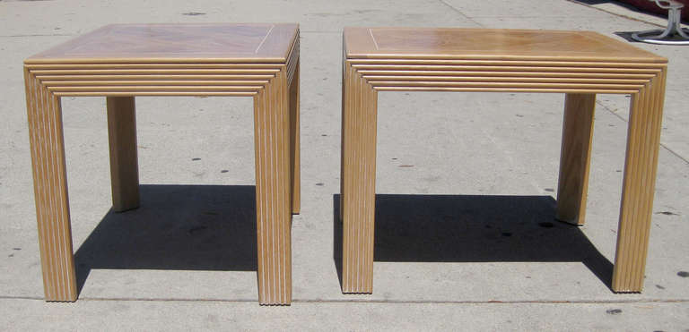 This pair of side or end tables features a sturdy, ribbed frame that supports a parquet surface, all in wood. The tables are marked underneath, 
