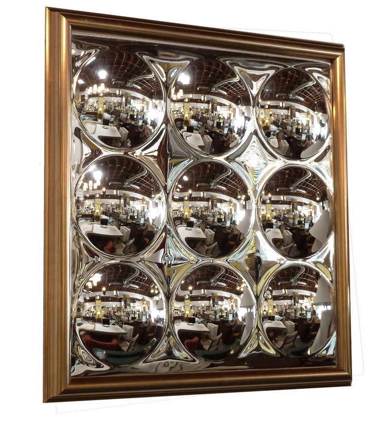 This glamorous square wall hanging features a mirrored finish embellished with a grid of nine convex circles. The result is an optically engaging work that is bound to enliven any space.