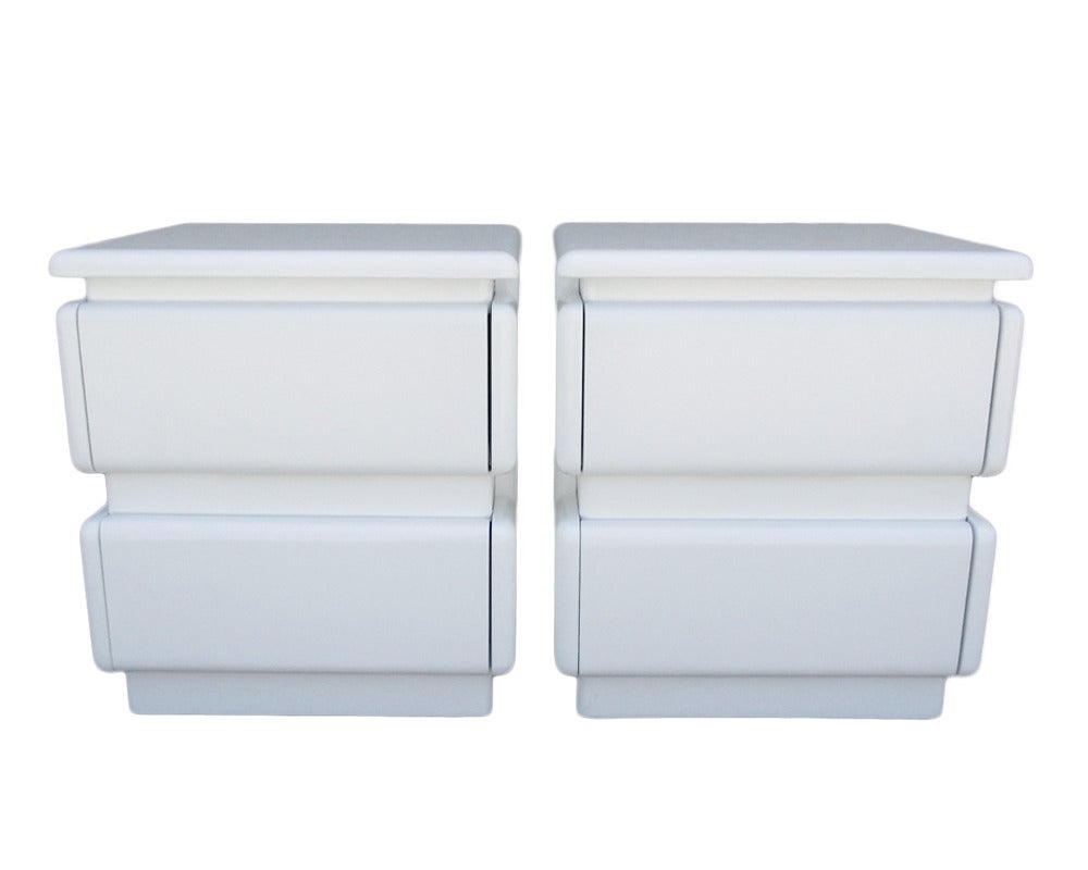 These graphic pair of night stands in white lacquer feature two drawers.