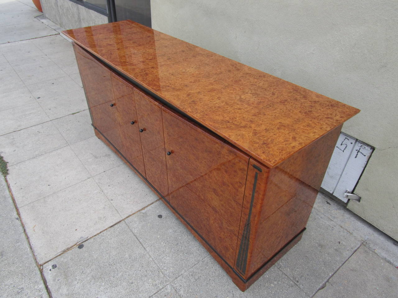 This high end  credenza has its original polyester varnish which is from far the sturdier and glossier varnish.
The 3 doors open on a glass shelf.
The knobs are black lacquered little balls.
The matching 7' dining table is available.