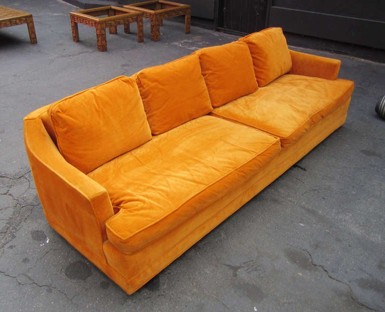 This wonderful four-seat sofa by Cal-Mode features its original orange velvet upholstery. It is supported by cylindrical wood legs.