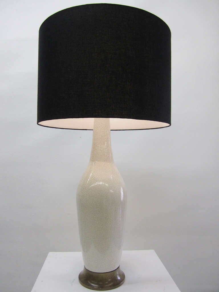 This large-scale, mid-century modern table lamp features a ceramic body with an intricate craquelure finish. The lamp rests on a sloped walnut base and is finished with a custom-made, black linen shade.