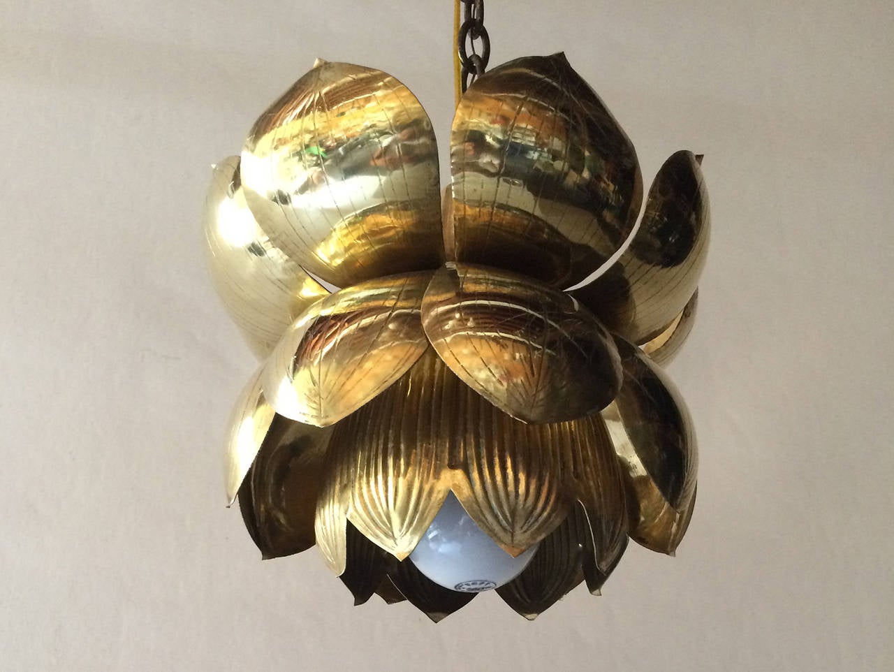 Single brass Mid-Century lotus pendant. Engraved and built in a lotus form, the hanging lamp is comprised of two rows of leaves and one internal row of flower petals.  The light is comprised of one bulb socket, newly polished and good wiring.