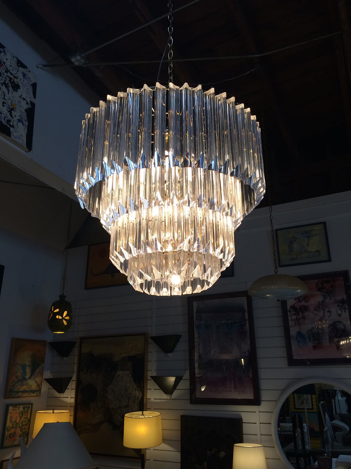 This is a large, four tiered, lucite chandelier.   Fixture is constructed with brass internal framework and 11 bulbs - two rows of five and a single bulb on the bottom. Measures 24"  across without the chain.